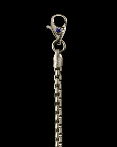 Close-up of a white gold chain with a clasp