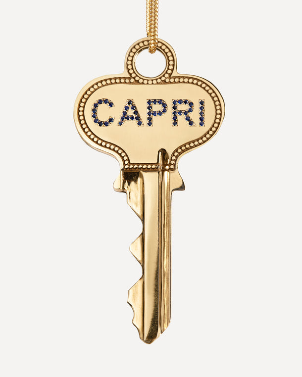 Gold key spinning with ‘CAPRI’ in sapphires on one side and engraved with ‘Meet Me by the Sea’ on the other side