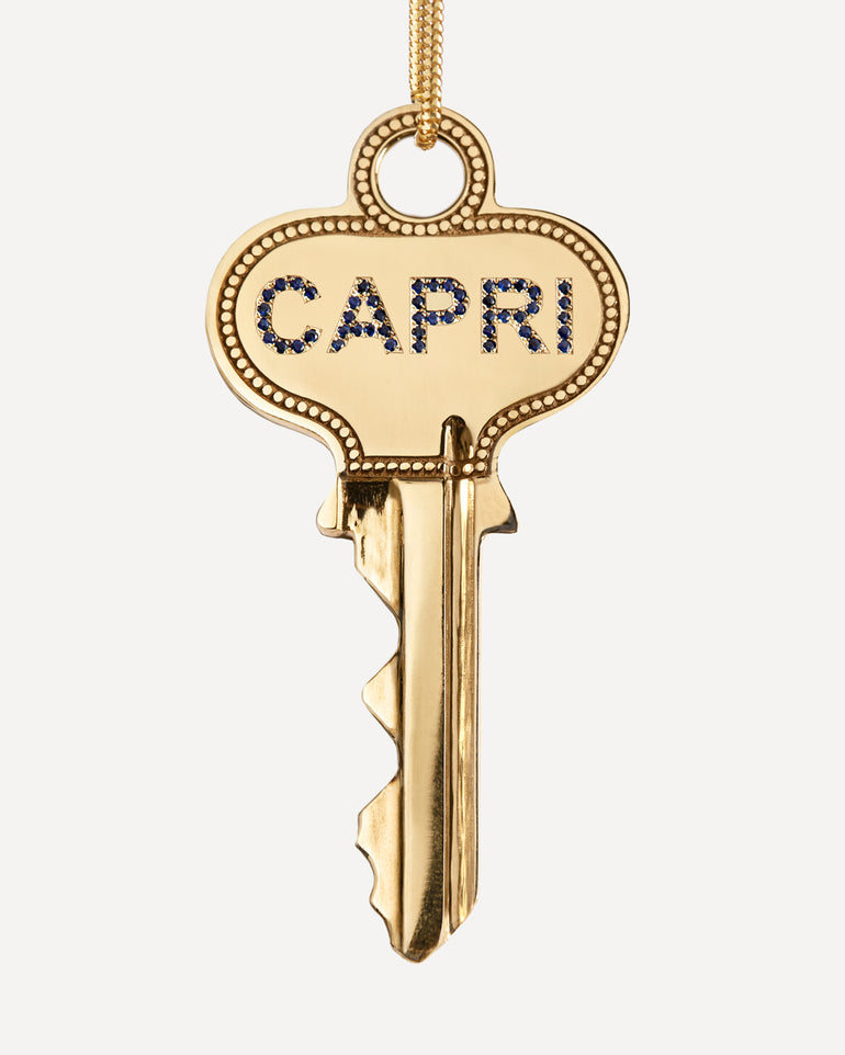 Gold key spinning with ‘CAPRI’ in sapphires on one side and engraved with ‘Meet Me by the Sea’ on the other side