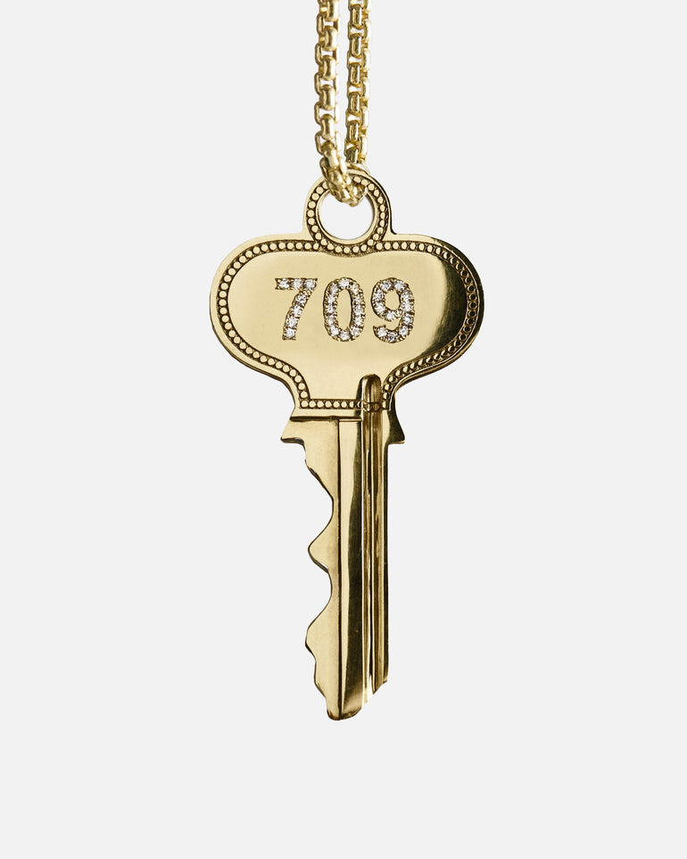 Gold key pendant spinning on a necklace